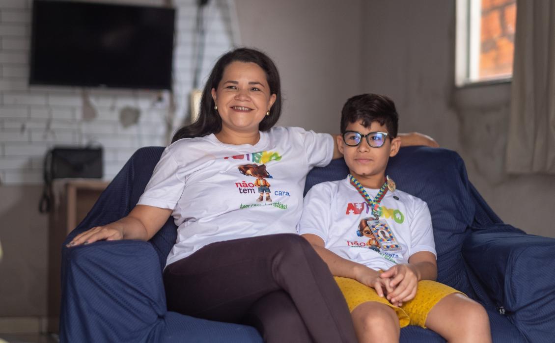 Ao lado da mãe, Cristiane, destaca como o cuidado da Clínica-Escola Mundo Autista transformou a vida
