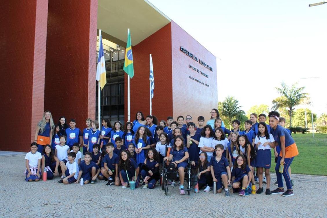 Janad Valcari com alunos na frente da Aleto